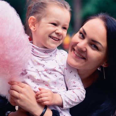 enfant et maman avec une barbe à papa rose