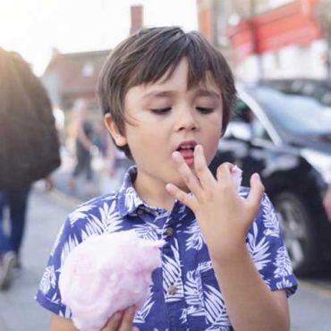 enfant tenant une barbe à papa