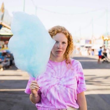 fille avec une barbe à papa bleue à la foire